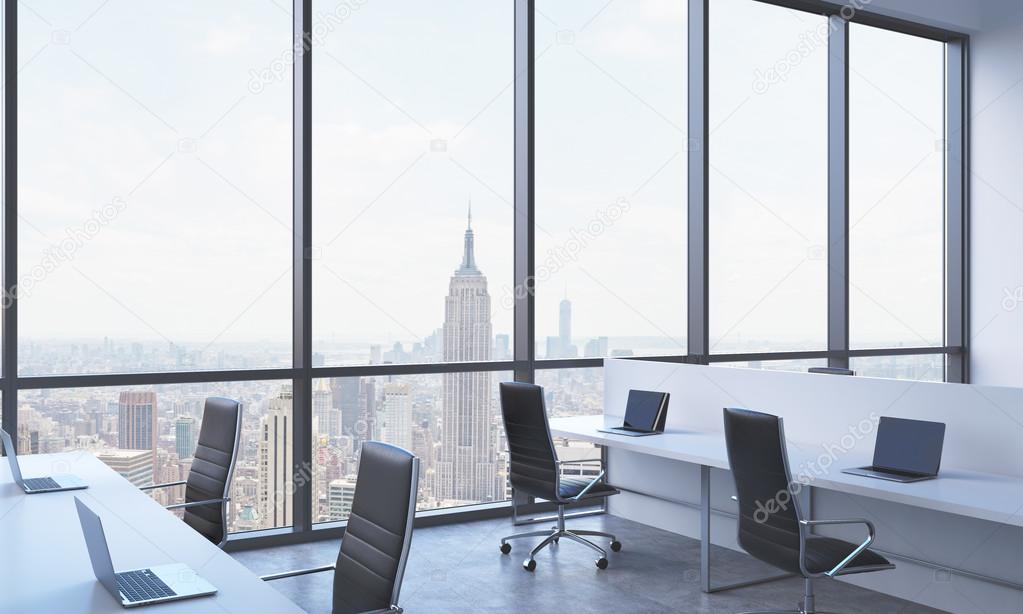 Workplaces in a bright modern open space office. White tables equipped with modern laptops and black chairs. New York panoramic view in the windows. 3D rendering.