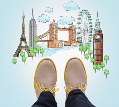 Top view of the casual man's brown shoes and drawn sketches of the most popular cities in the world. The concept of travelling. London, Singapore, Pisa, Paris. Light blue background.
