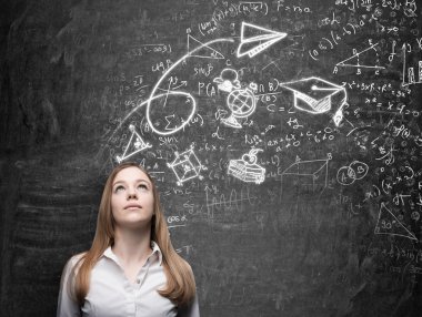 A beautiful lady is dreaming about graduation. Math formulas, an arrow, geometric figures are drawn on the black chalkboard.