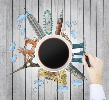 Top view of a coffee cup and the hand draws colourful sketches of the most famous cities in the world. The concept of travelling. London, Singapore, Pisa, Paris. Wooden planks table as a background.