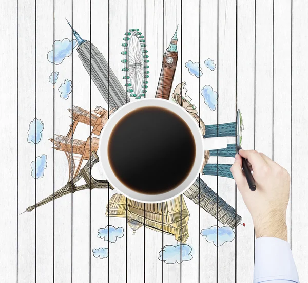 Top view of a coffee cup and the hand draws colourful sketches of the most famous cities in the world. The concept of travelling. London, Singapore, Pisa, Paris. White wooden planks background.