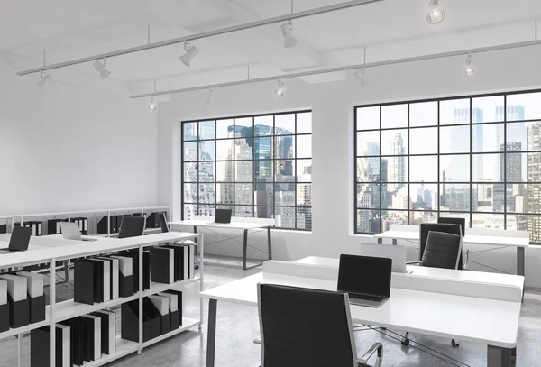 Workplaces in a bright modern loft open space office. Tables equipped with laptops; corporate documents' shelves. New York in the panoramic windows. 3D rendering. — ストック写真