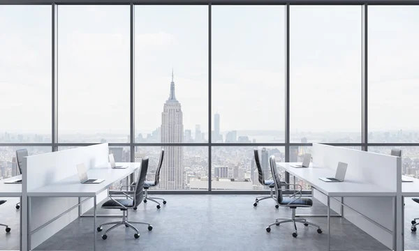 Arbeitsplätze in einem hellen, modernen Großraumbüro. weiße Tische mit modernen Laptops und schwarzen Stühlen. New York in den Panoramafenstern. 3D-Darstellung. — Stockfoto