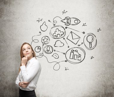A young lady is thinking about an optimisation scheme in some business process. Some connected icons are drawn on the concrete wall.