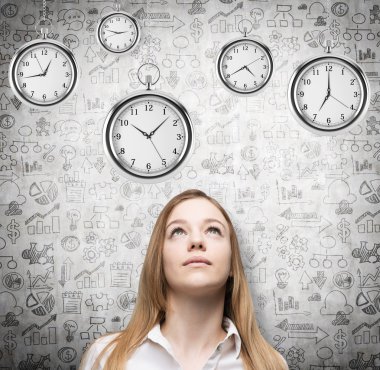 A portrait of a beautiful lady who is looking at the hovering pocket watches. A concept of a value of time in business. Business icons are drawn over the concrete background.