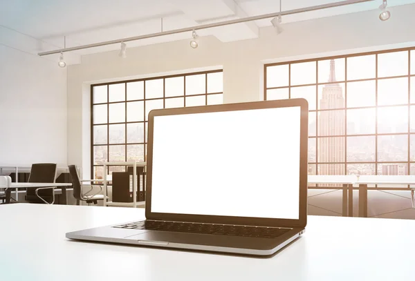 Um local de trabalho em um escritório moderno brilhante. Uma mesa de trabalho está equipada com um laptop moderno com espaço de cópia em branco na tela. Prateleiras de documentos. Vista de Nova Iorque nas janelas. Imagem tonificada. Renderização 3D . — Fotografia de Stock