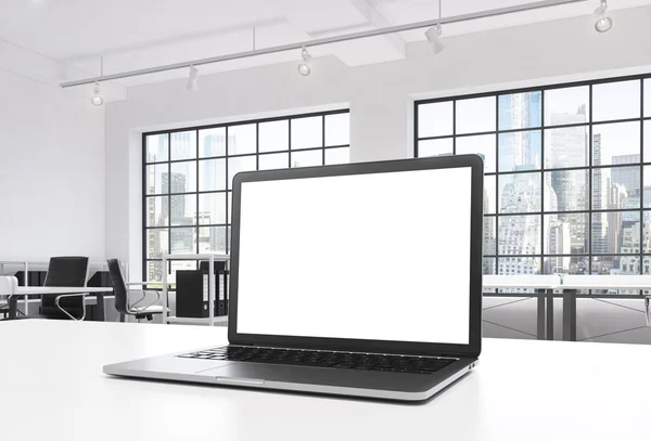 A workplace in a bright modern loft open space office. A working desk is equipped with a modern laptop with white copy space in the screen. Docs shelves. New York view in the windows. 3D rendering. — Zdjęcie stockowe