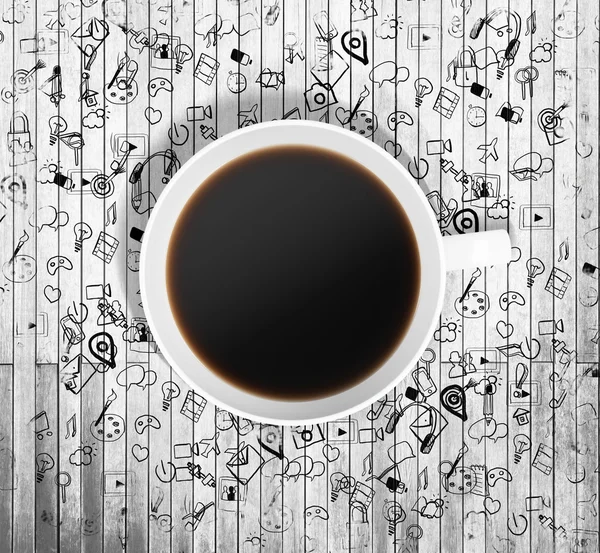 Vista superior de una taza de café e iconos de negocios dibujados en la mesa de madera alrededor de la taza. Renderizado 3D . — Foto de Stock