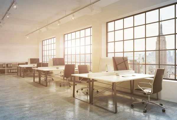 Workplaces in a sunset loft open space office. Tables are equipped with computers; book shelves. New York panoramic view. A concept of a high quality consulting services. Toned image. 3D rendering. — Stockfoto