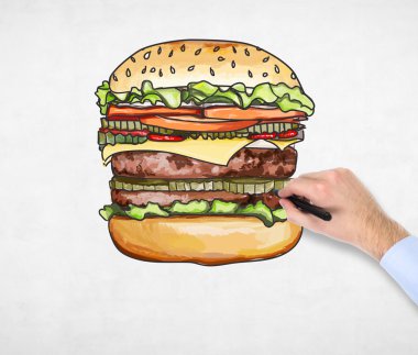 A man's hand is drawing a colourful burger. A concept of fast food. A concrete background.