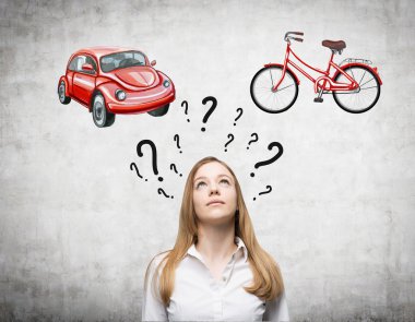 A beautiful woman is trying to chose the most suitable way for travelling or commuting. Two sketches of a car and a bicycle are drawn on the concrete wall. Question marks are around woman's head.
