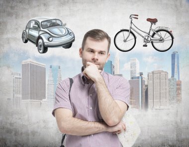 A handsome man in casual shirt is trying to chose the most suitable way for travelling or commuting in the city. Sketches of a car, a bicycle and New York city are on the concrete background.