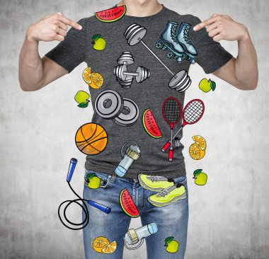 A man in a good physical form is pointing out the fingers on the colourful sport icons. Concrete background. a concept of a healthy lifestyle.