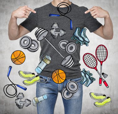 A man in a good physical form is pointing out the fingers on the colourful sport icons. Concrete background. a concept of a healthy lifestyle.