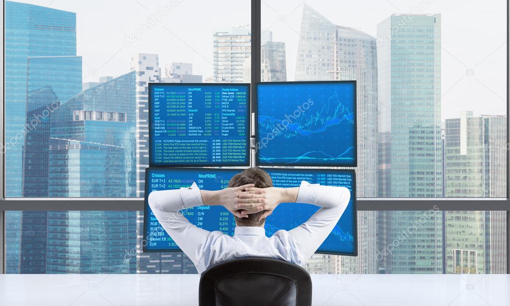 Rear view of a relaxing trader who is sitting in front of a trading station which consists of four screens with financial data. A concept of forex trading. Singapore panoramic view.