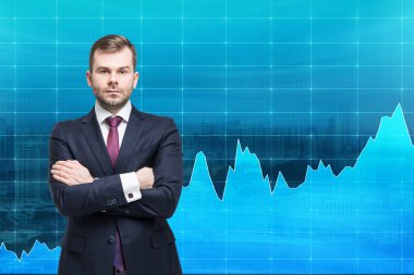 businessman with hands crossed standing in front of a blue graph