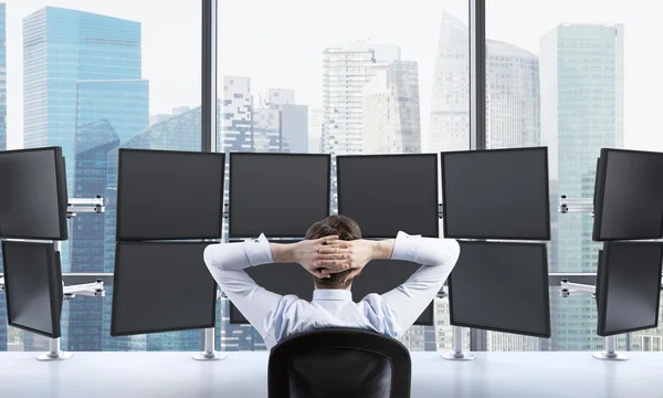 Man with hands locked on back of the head sitting in front of ei — Stock fotografie