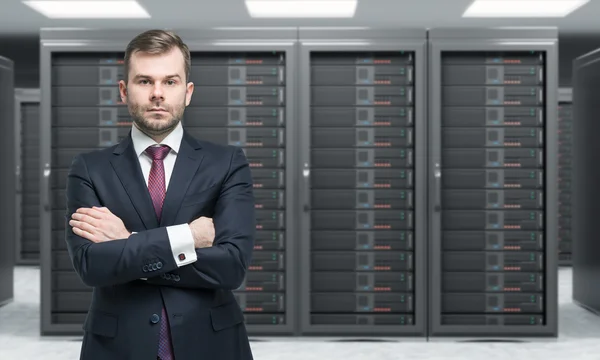 Young man standing with hands crossed in front of server for dat Royalty Free Stock Photos