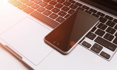 smartphone on laptop keyboard in the office, communication