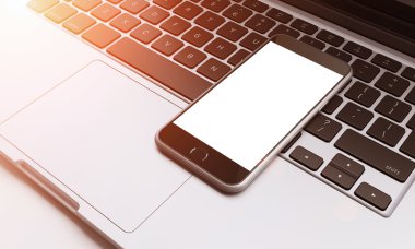smartphone on laptop keyboard in the office, communication