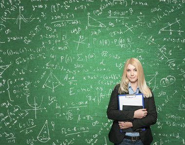 young girl holding note books, green blackboard with signs at th