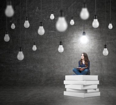 woman sitting on a pile of books thinking about problem