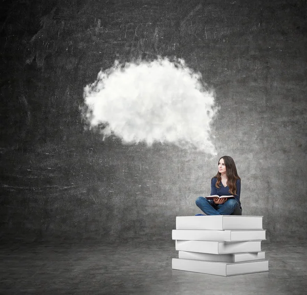 Woman sitting on a pile of books thinking about problem — Stockfoto