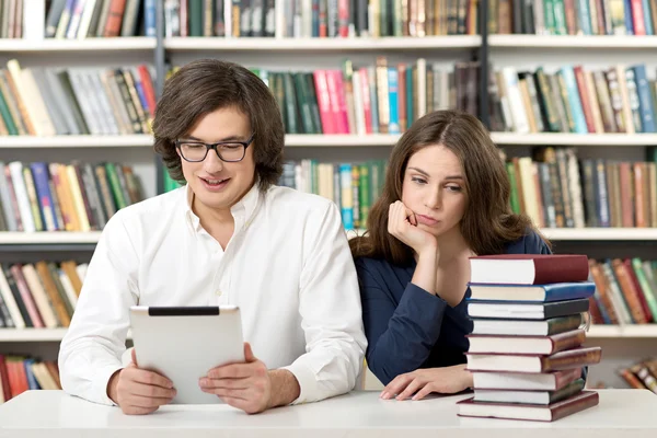Uomo e donna che studiano e lavorano in biblioteca — Foto Stock