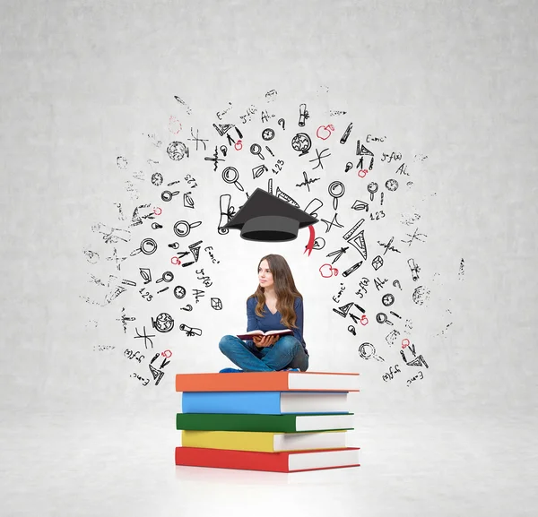 Mujer en un montón de libros un libro de rodillas pensando en educat —  Fotos de Stock