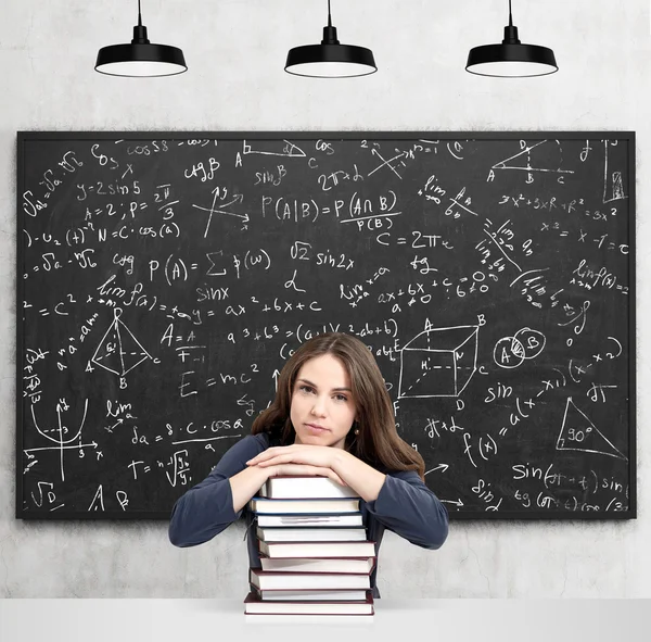 Frau mit Händen und Kopf auf Bücherstapel denkend — Stockfoto