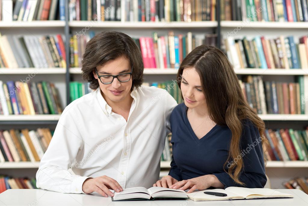 man and woman studying and working in the library