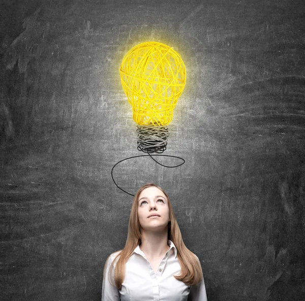 Vrouw op zoek naar een lamp denken over probleem oplossing — Stockfoto