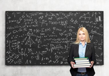 girl with books in front of blackboard