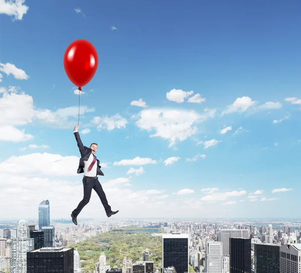 Uomo che vola con palloncino sopra la città — Foto Stock