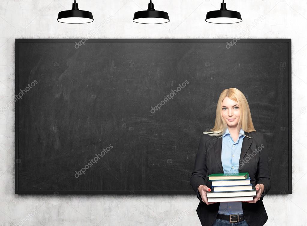 girl with books in front of blackboard