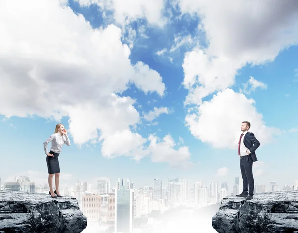 Two businesspeople standing on rock on city background — 스톡 사진