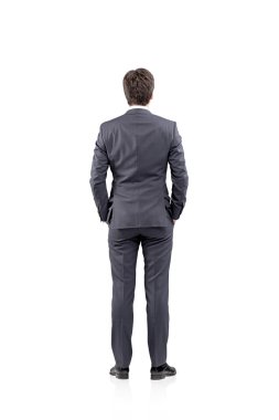 Young businessman standing with his hands in pockets. Back view. Concept of thinking
