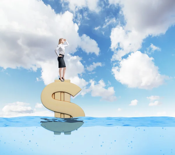 Young businesswoman standing confidently on  huge gold dollar sign afloat and looking forward, sea background, blue sky, Concept of wealth. — ストック写真