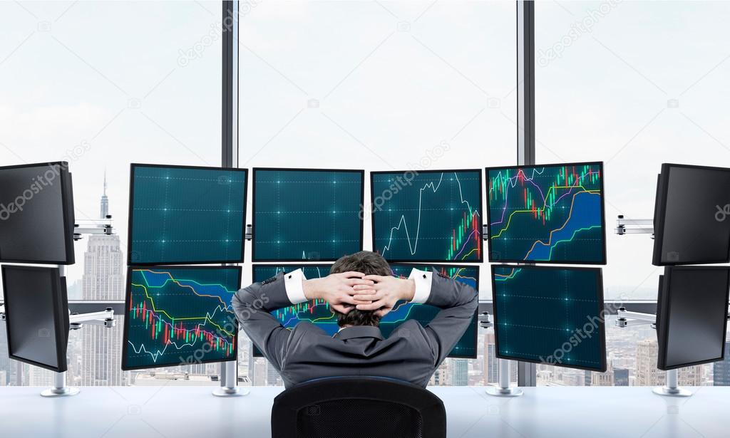 Ttrader at rest in front of screens