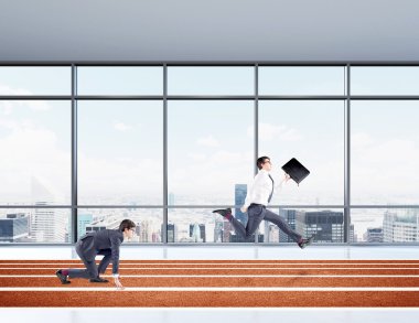 Two young businessmen competing on the track. One in crouch start, the other running forward with a black folder.