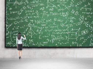 Woman solving problems on blackboard