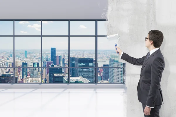 Businessman covering office view with paint — Stok fotoğraf