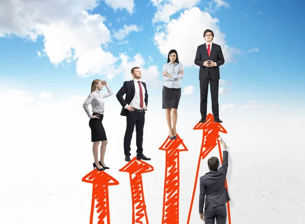 A businessman painting four red vertical arrows that are arranged as a bar chart, four people standing on them. — Stock Photo, Image