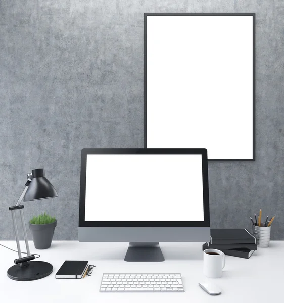 Workplace: a computer with blank screen, lamp, plant, organizer and glasses, cup, mouse, three datebooks and  pencils; white blank frame on the wall. Front view. Concept of work.