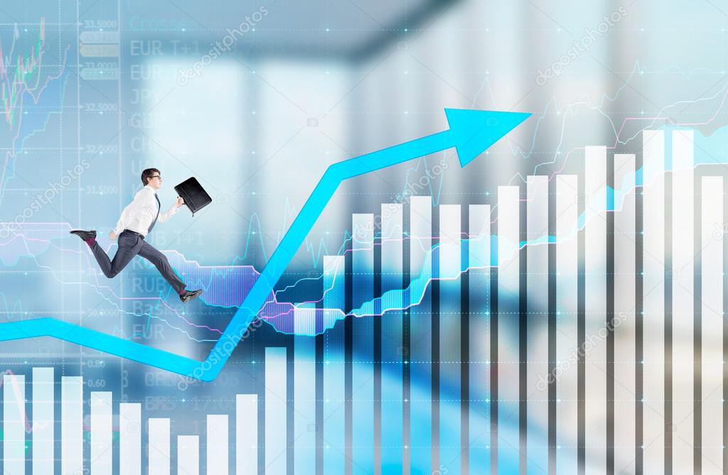 Successful young businessman with a folder in hand running up along a blue rising graph. Blurred office background.
