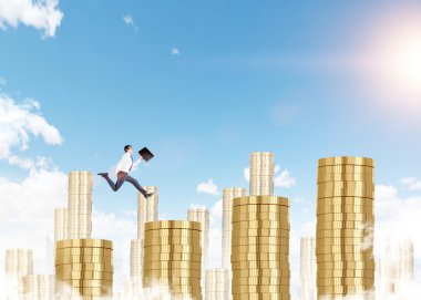 A young businessman running up a career ladder in shape of a bar chart made of coins, blue sky at the background.