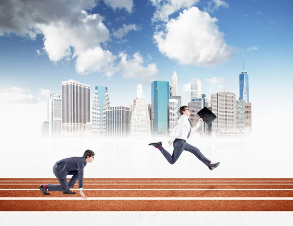 Two young businessmen competing on the track. One in crouch start, the other running forward with a black folder. — 스톡 사진