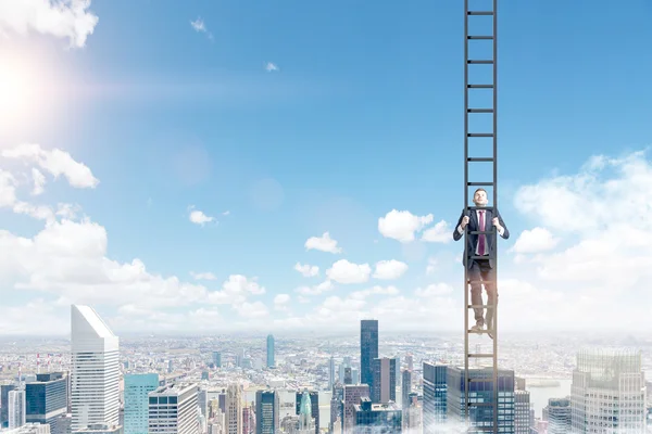 A young businessman in a suit climbing a ladder — Stock Photo, Image