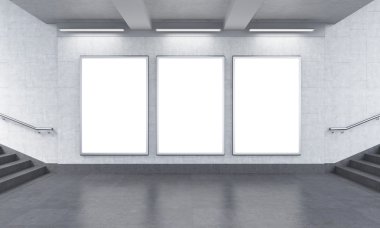 Three vertical billboards in the underground, stairs up to the left.