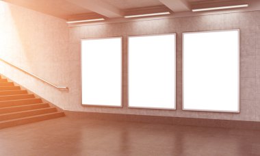 Three vertical billboards in the underground, stairs up to the left.